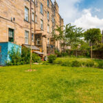 Lush garden, traditional stone buildings.