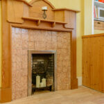 Tiled fireplace with wood surround.