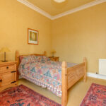 Wooden bed, wardrobe, nightstands.
