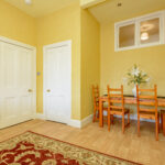 Dining area, yellow walls.
