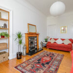 Red couches, wooden floor.