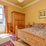 Traditional bedroom, yellow walls.
