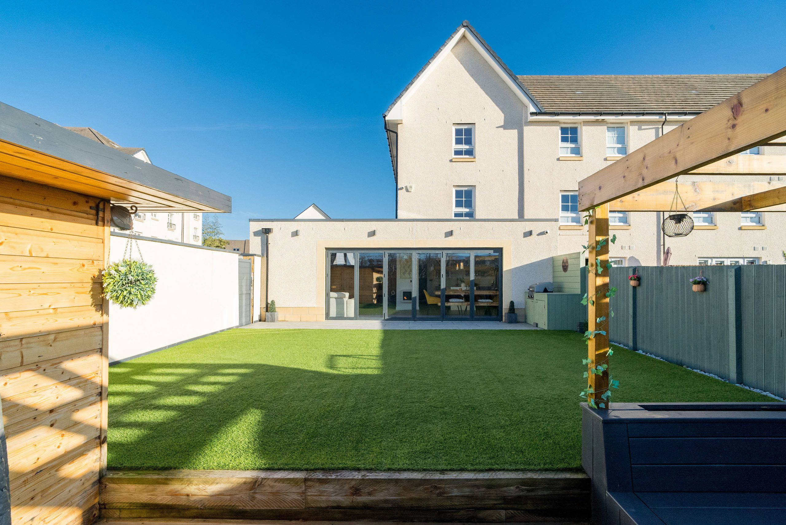 Back garden view with artificial turf and outdoor seating