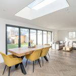 Dining and living area with a large skylight and garden view