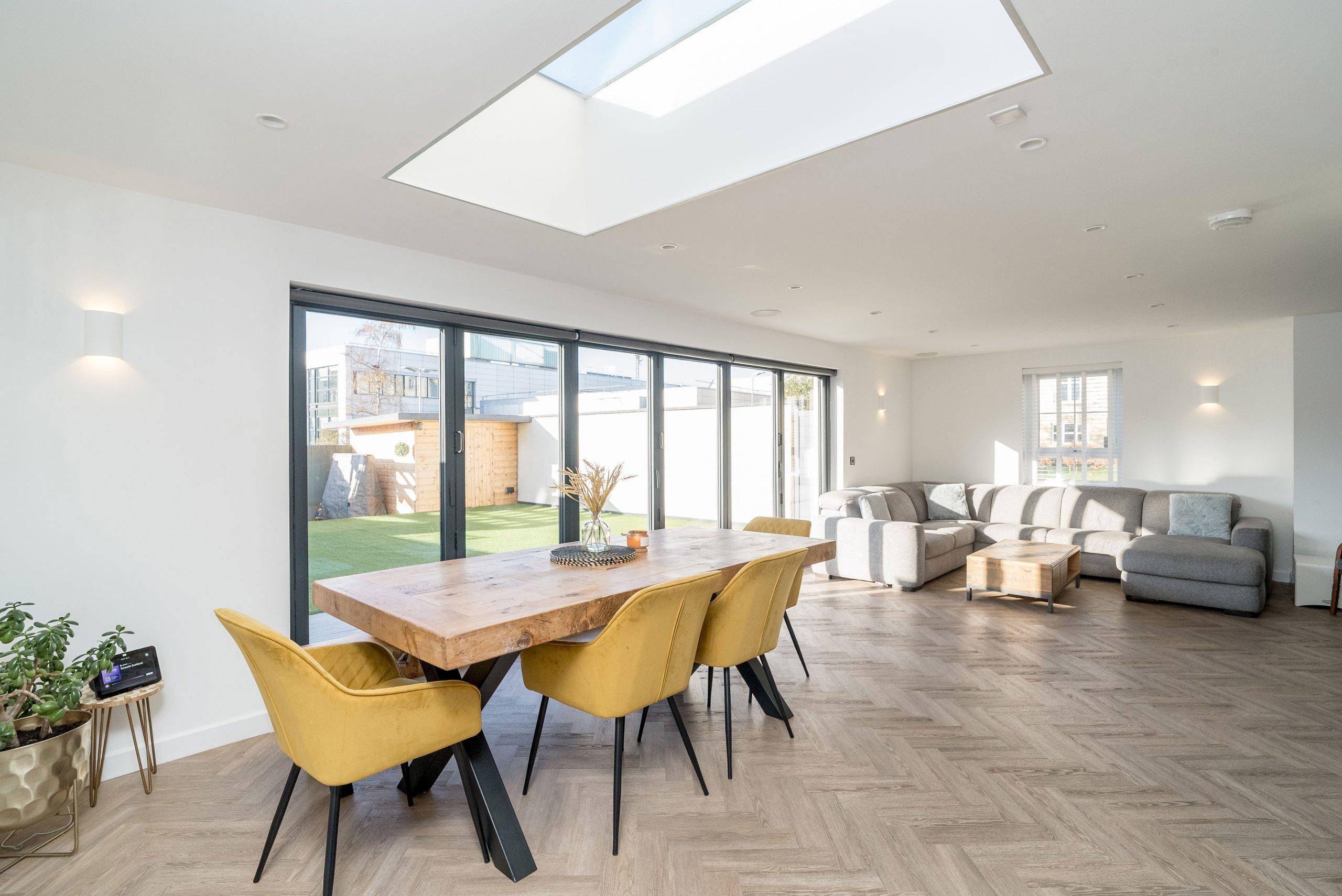 Dining and living area with a large skylight and garden view